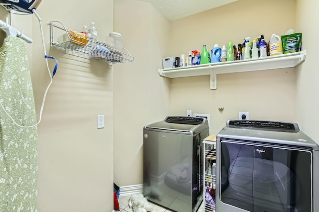 washroom featuring tile patterned flooring, laundry area, baseboards, and independent washer and dryer