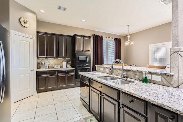 kitchen with visible vents, black appliances, decorative backsplash, and a sink