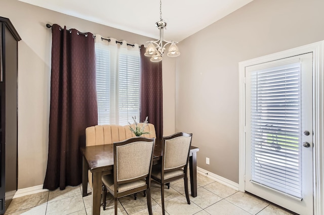 dining room featuring baseboards, a healthy amount of sunlight, a chandelier, and light tile patterned flooring