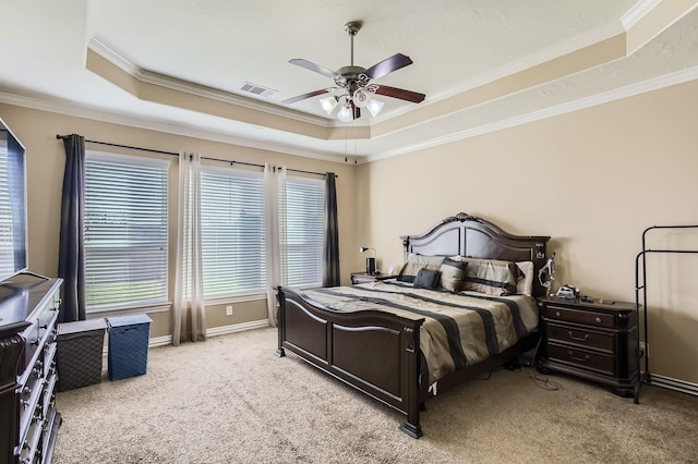 carpeted bedroom featuring a tray ceiling, visible vents, and ornamental molding