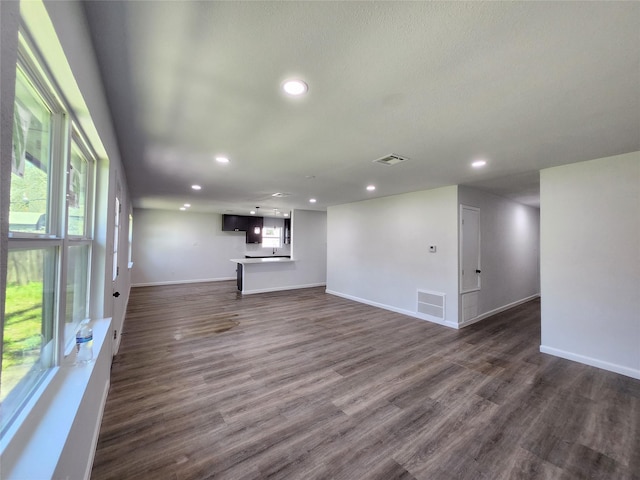 unfurnished living room with recessed lighting, visible vents, and dark wood-style floors