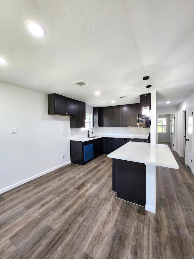 kitchen featuring visible vents, dark wood finished floors, light countertops, a textured ceiling, and dishwasher