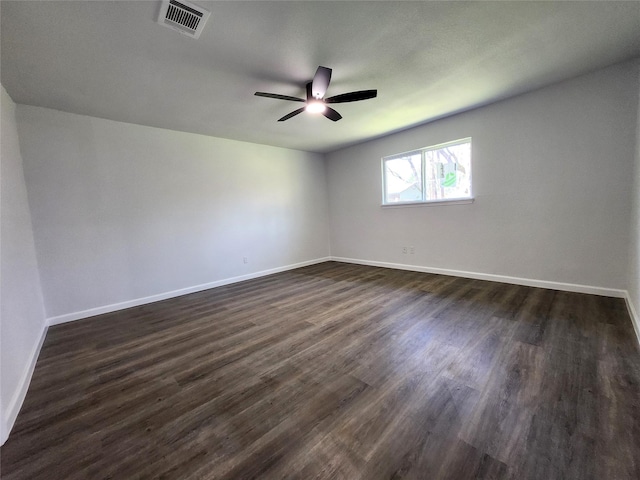 unfurnished room with visible vents, a ceiling fan, dark wood-type flooring, and baseboards