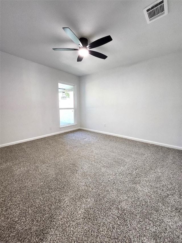 carpeted spare room featuring visible vents, a ceiling fan, and baseboards