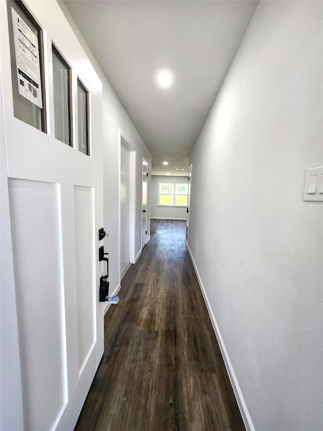 corridor featuring dark wood-style floors and baseboards