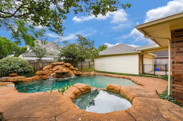 view of pool with a fenced backyard and a pool with connected hot tub