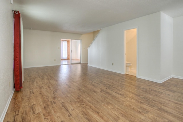 unfurnished room featuring baseboards and light wood-style floors