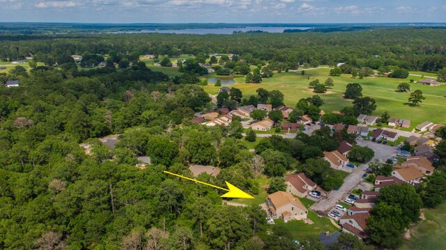 aerial view with a residential view, view of golf course, a forest view, and a water view