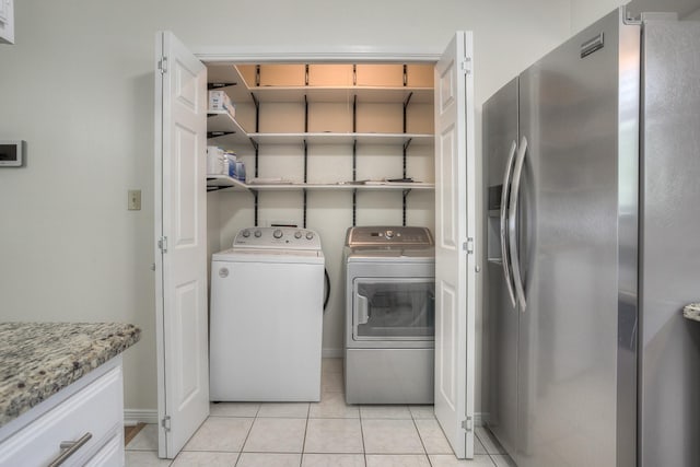 laundry room with light tile patterned floors, laundry area, baseboards, and separate washer and dryer