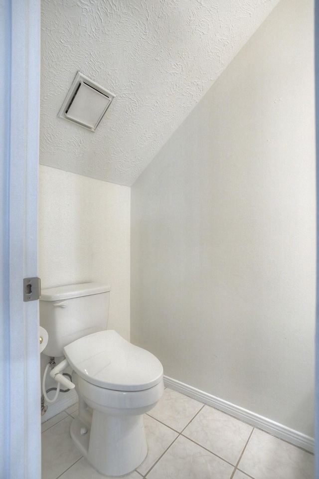 bathroom featuring tile patterned floors, a textured ceiling, toilet, and baseboards