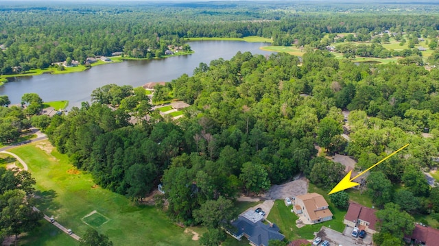 birds eye view of property featuring a forest view and a water view