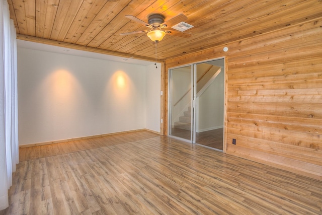 spare room featuring visible vents, wood ceiling, stairs, wood finished floors, and a ceiling fan