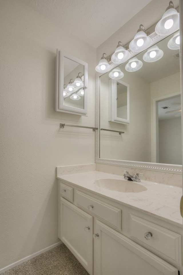 bathroom featuring visible vents, vanity, and baseboards