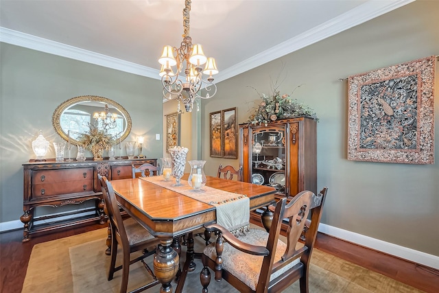 dining room featuring baseboards, an inviting chandelier, wood finished floors, and crown molding