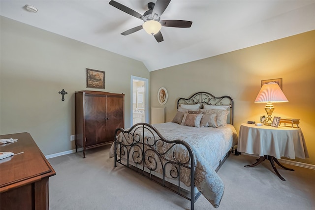 bedroom with a ceiling fan, ensuite bath, carpet floors, baseboards, and vaulted ceiling