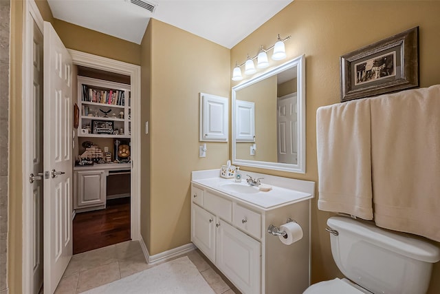 bathroom with vanity, visible vents, baseboards, tile patterned flooring, and toilet