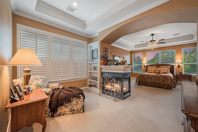 bedroom with a tray ceiling, crown molding, visible vents, and carpet floors