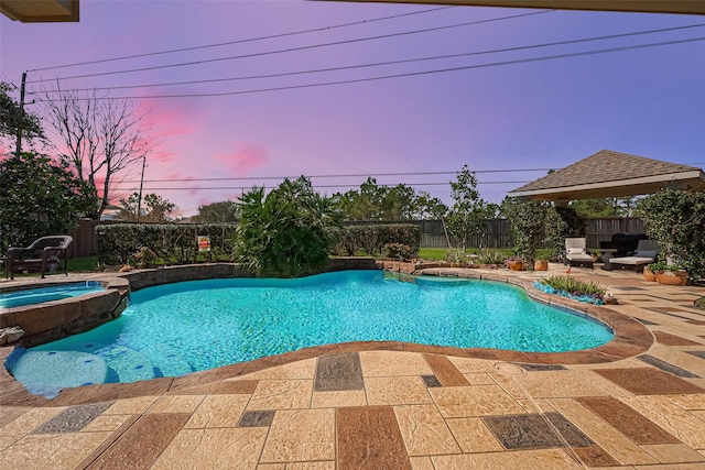 view of swimming pool with a patio, a fenced backyard, and a pool with connected hot tub