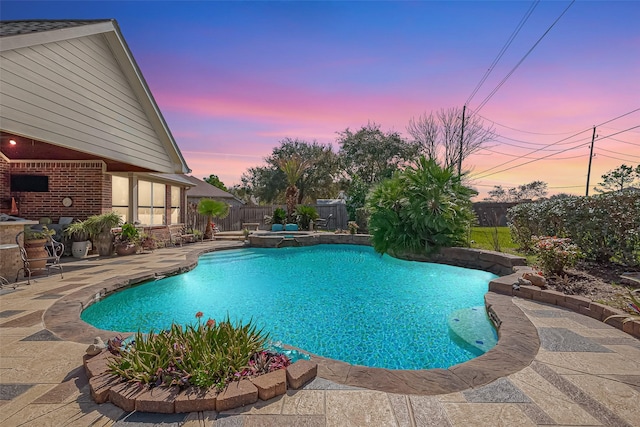 view of pool featuring a patio area, a pool with connected hot tub, and a fenced backyard