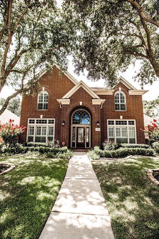 view of front of home featuring brick siding and a front yard