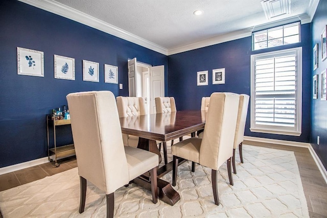 dining area with a healthy amount of sunlight, wood finished floors, baseboards, and ornamental molding