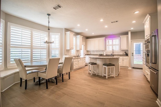 dining area featuring recessed lighting, visible vents, and light wood finished floors