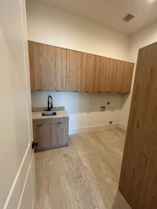 laundry area with visible vents, cabinet space, a sink, washer hookup, and light wood-type flooring