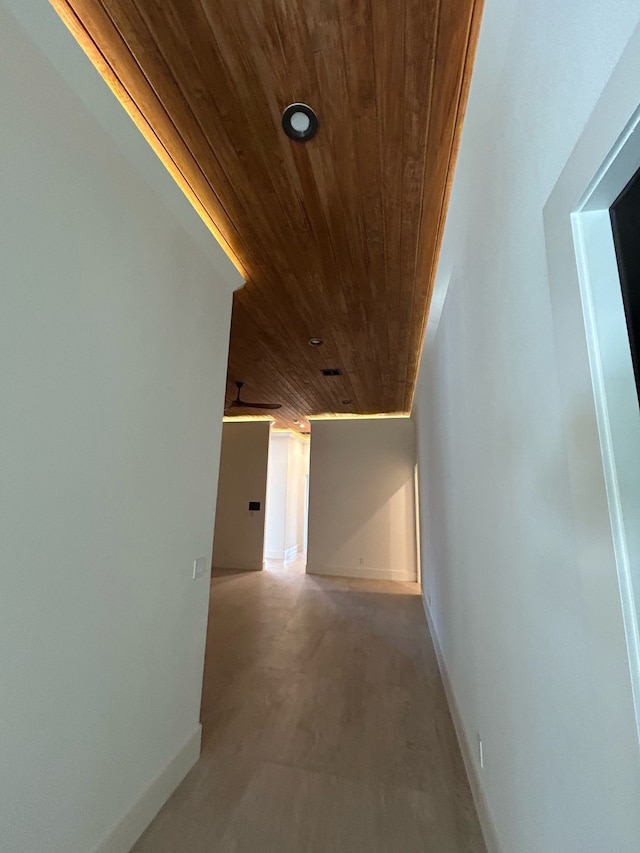 hall featuring wooden ceiling and baseboards