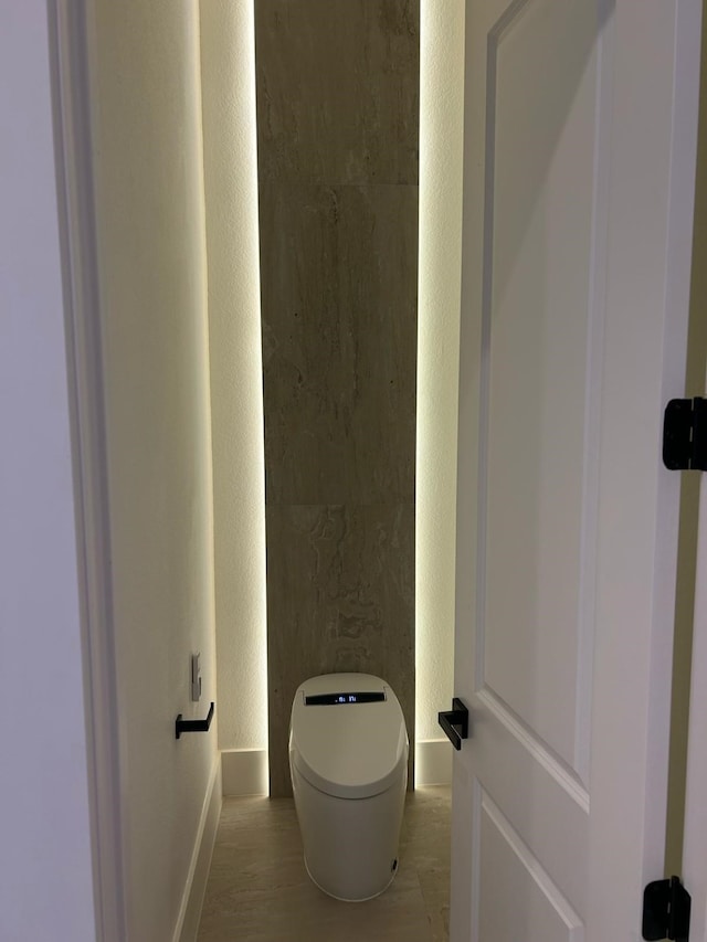 bathroom with toilet and baseboards