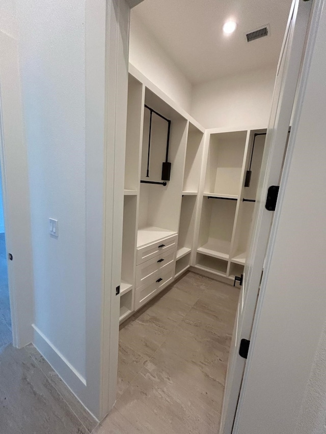 spacious closet with light wood-type flooring and visible vents