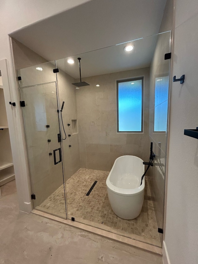 full bath featuring recessed lighting, a freestanding bath, and a shower stall