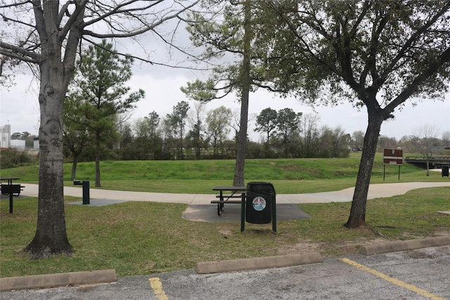 surrounding community with a lawn and uncovered parking