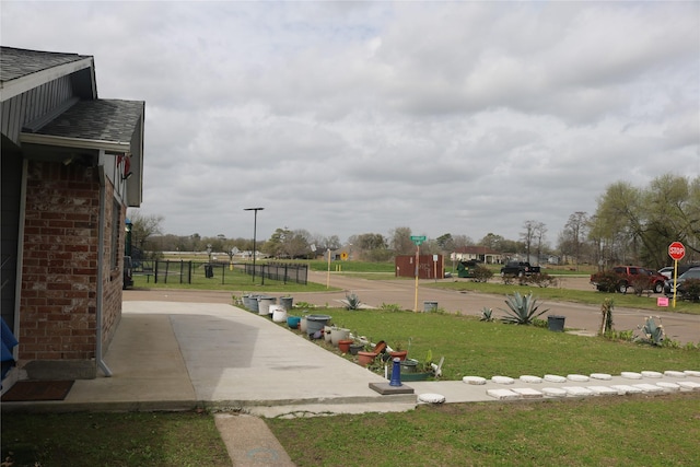 view of property's community featuring a lawn and fence