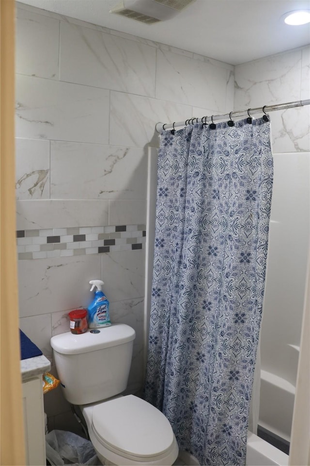 bathroom with visible vents, toilet, shower / bath combo, and vanity