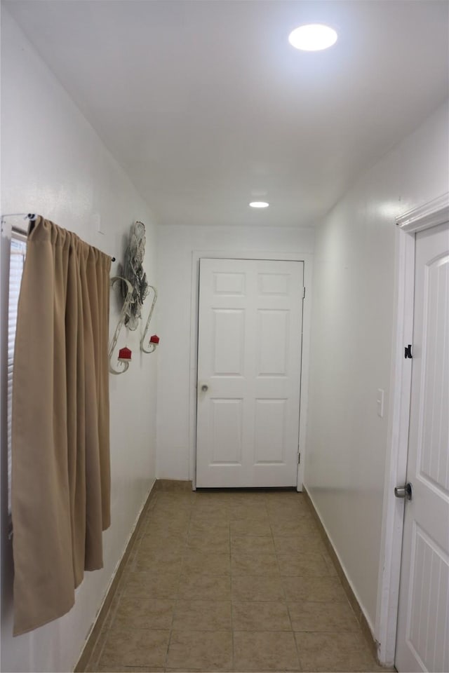 hall with light tile patterned floors, recessed lighting, and baseboards