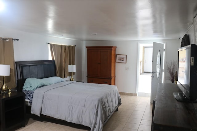 bedroom with light tile patterned floors and baseboards