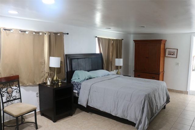 bedroom featuring light tile patterned floors and baseboards