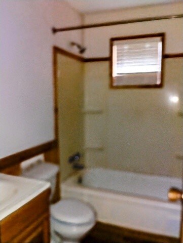 bathroom featuring vanity, shower / bathing tub combination, and toilet