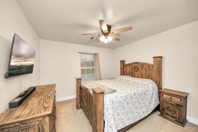 bedroom with light colored carpet, baseboards, and ceiling fan