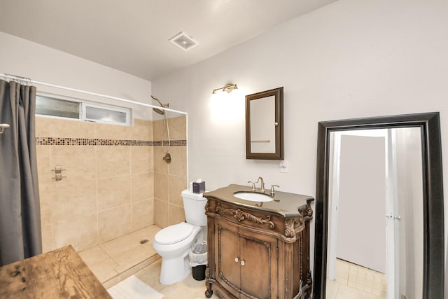 bathroom with tile patterned floors, visible vents, toilet, tiled shower, and vanity