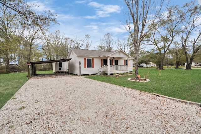 ranch-style home featuring a front yard, roof with shingles, gravel driveway, a porch, and a carport