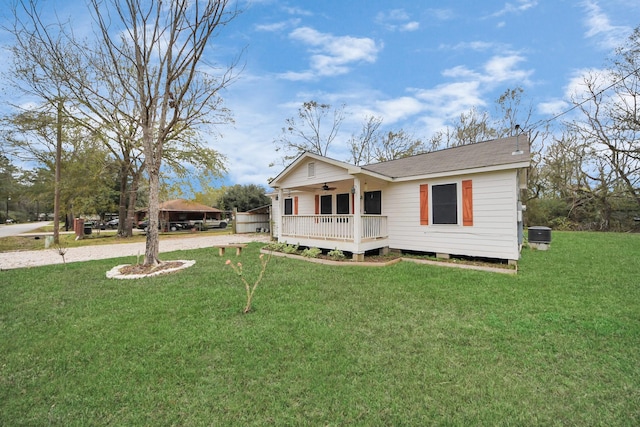 view of front facade with a shingled roof, ceiling fan, central AC, a front yard, and covered porch