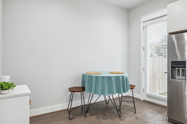 dining space featuring baseboards and wood finished floors