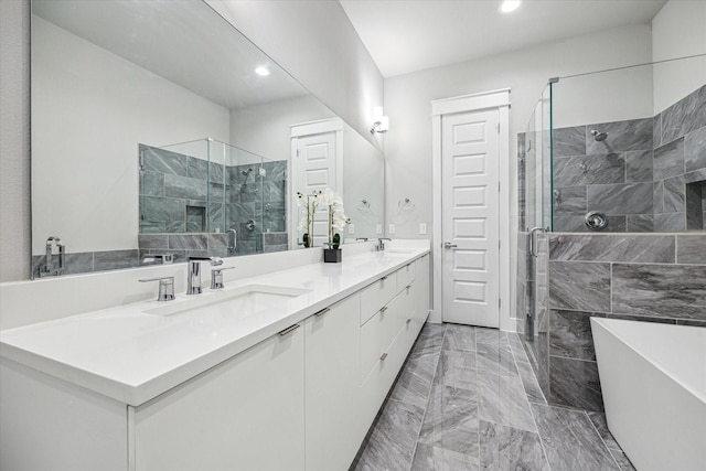 bathroom with a freestanding tub, a stall shower, a sink, recessed lighting, and double vanity