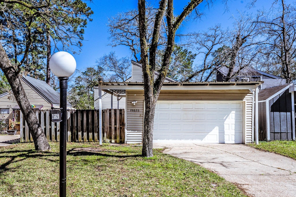 view of side of home featuring a yard, a detached garage, an outdoor structure, and fence