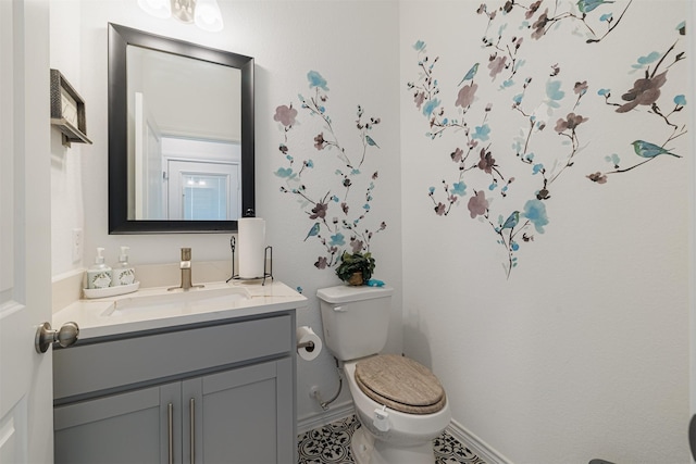 bathroom with vanity, toilet, and baseboards