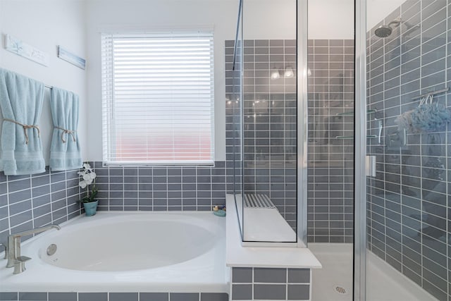 full bathroom featuring a shower stall and a garden tub