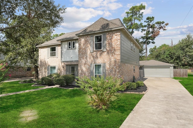 view of front facade featuring brick siding, a detached garage, an outbuilding, and a front yard