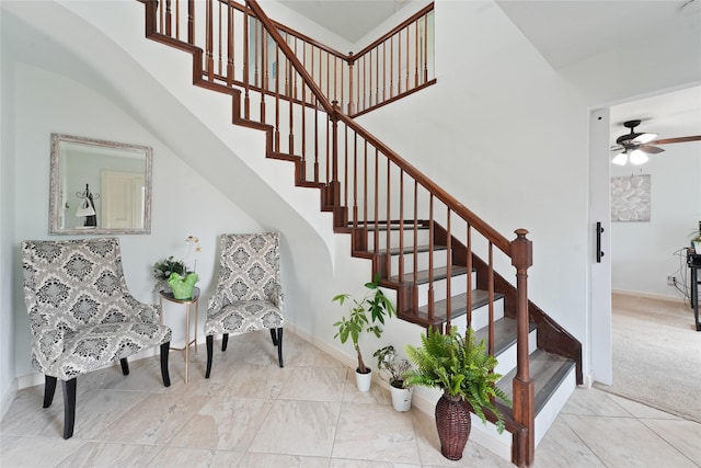 stairway featuring baseboards, carpet floors, and a ceiling fan