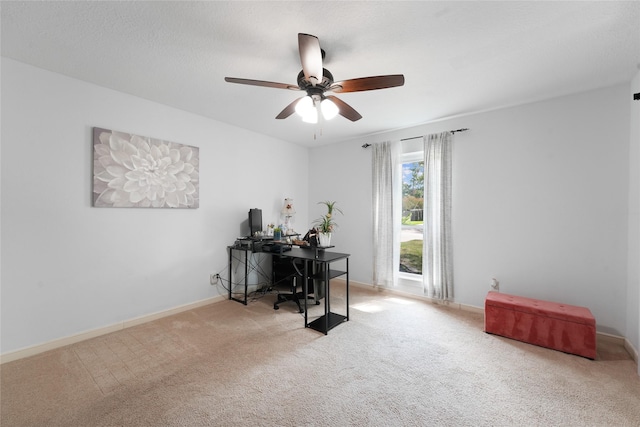 carpeted office space with baseboards and ceiling fan